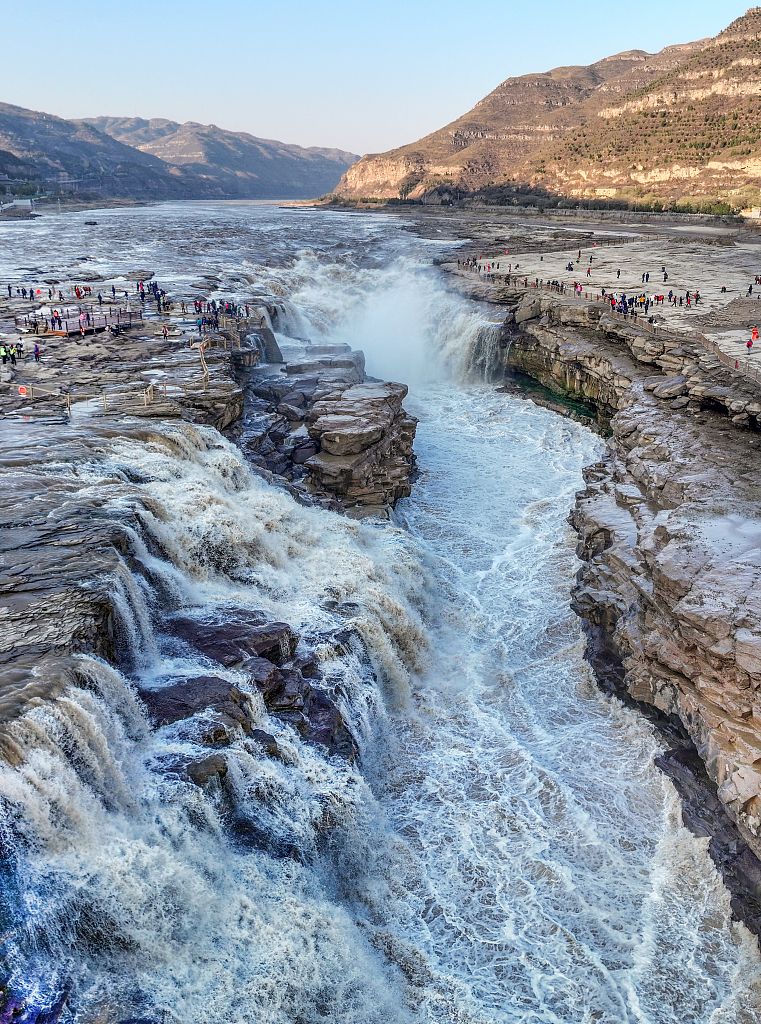 Banyak wisatawan datang untuk mengagumi pemandangan air terjun yang menakjubkan ini dari tepi Sungai Kuning di Yan'an