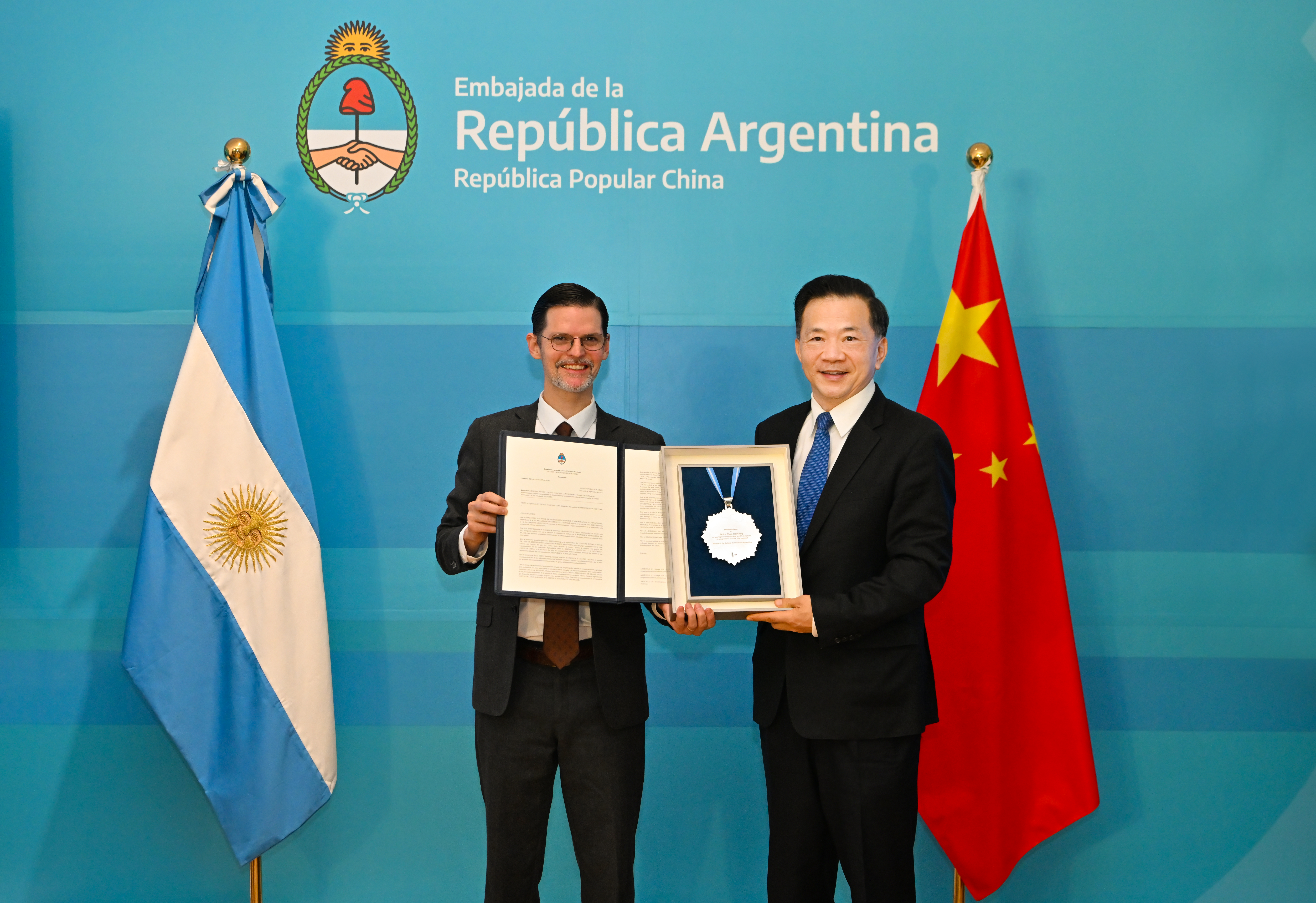 Penghargaan tersebut diberikan kepada Shen oleh Duta Besar Argentina untuk Tiongkok Sabino Vaca Narvaja atas nama Presiden Alberto Fernandez atas kontribusi Shen terhadap pertukaran budaya dan orang-ke-orang serta kerja sama antara Tiongkok dan negara Amerika Latin