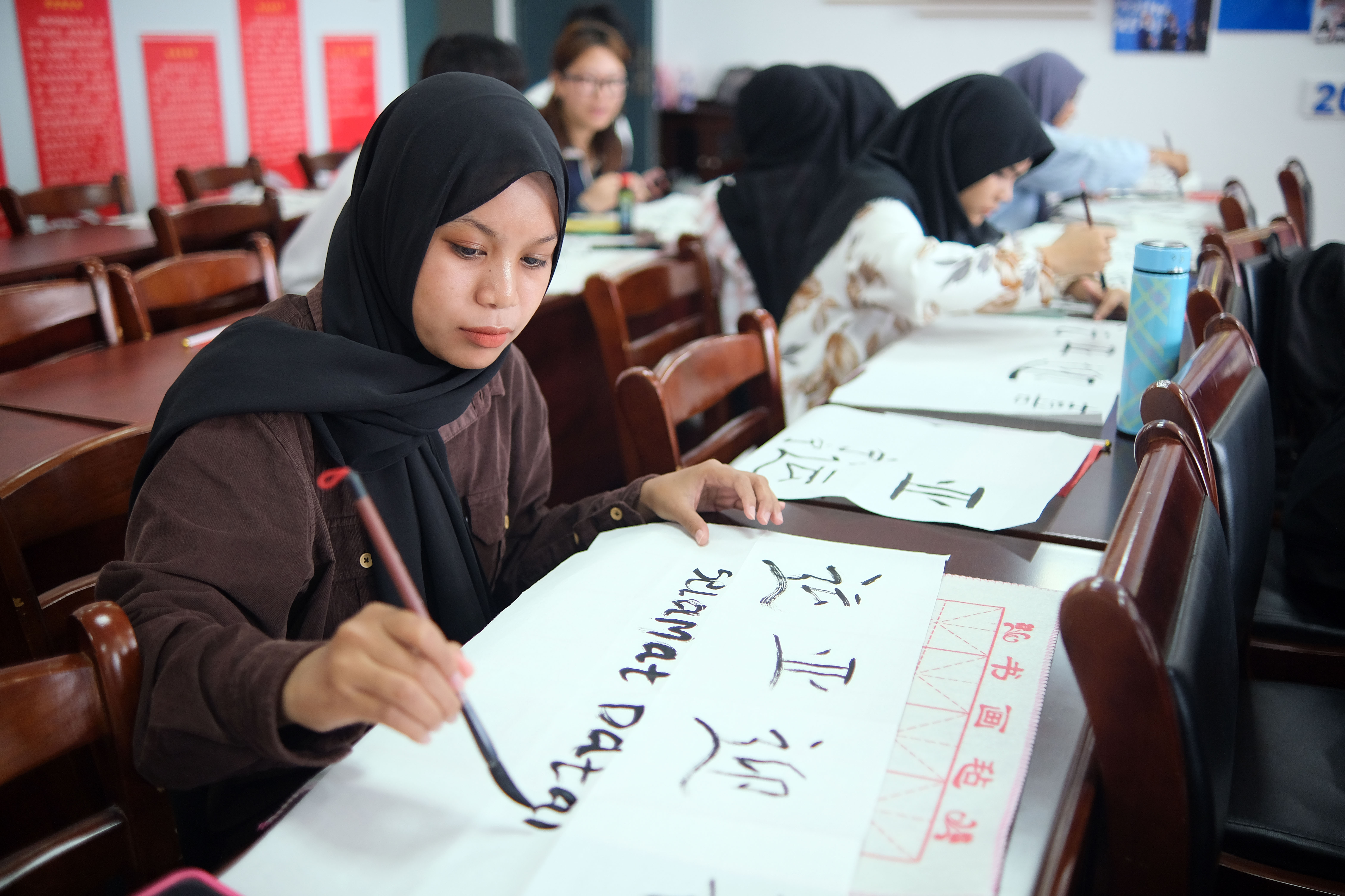 Memadukan karakter Mandarin dengan ungkapan dari negaranya masing-masing pelajar internasional dari Pakistan Thailand Indonesia dan negara lain mengungkapkan harapan dan harapan mereka terhadap ajang olahraga terbesar di Asia tersebut