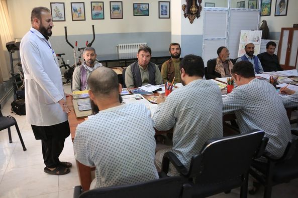 Sambil mengenakan pakaian rumah sakit