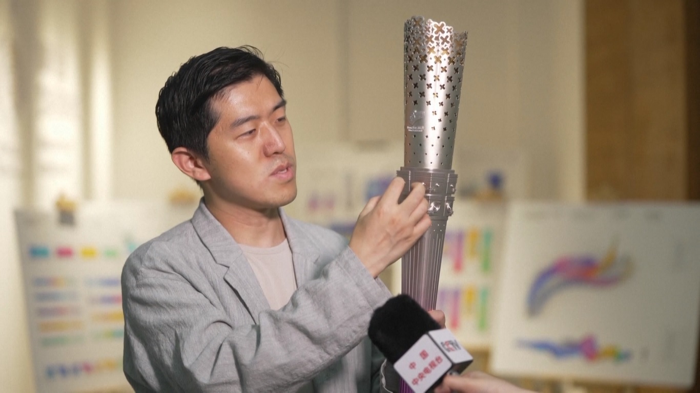 Obor tersebut dinamakan Laurels Desainnya terinspirasi dari batu giok kuno Cong yang ditemukan di kota kuno Liangzhu